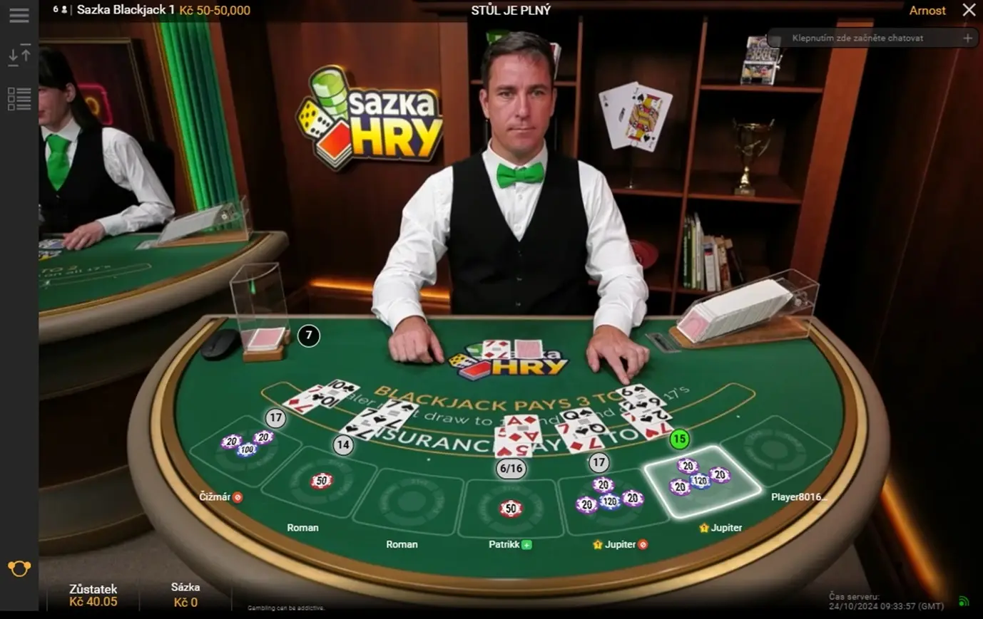 Radioservis Blackjack – plný stůl hráčů a rozdávající krupiér ve studiu live casina Živá hra blackjack s krupiérem a hráči u plného stolu v online kasinu